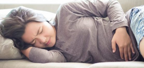 Woman Suffering from Stomachache on Sofa